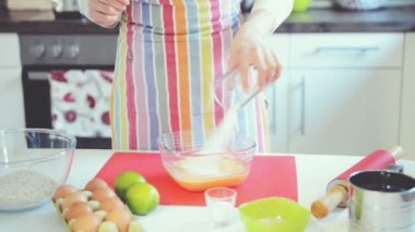 Genç kadın mutfakta Paskalya pastası pişirmek için limon ve hamuru ovalıyor.