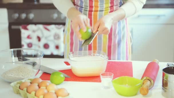 若い女性こする石灰と混合生地用ベーキングケーキのためのイースターでキッチン — ストック動画