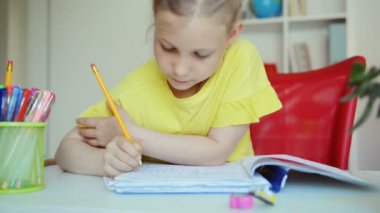 Evdeki masada ödev yapan sevimli liseli kızın videosu.