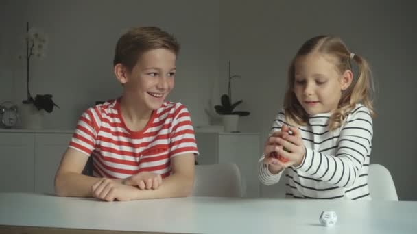 Två Lyckliga Barn Leker Med Tärningar Hemma — Stockvideo