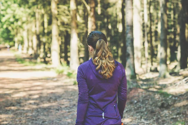 年轻漂亮的女人在阳光灿烂的森林里慢跑和锻炼 — 图库照片