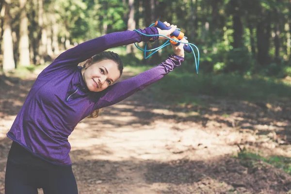 年轻漂亮的女人在阳光灿烂的森林里慢跑和锻炼 — 图库照片