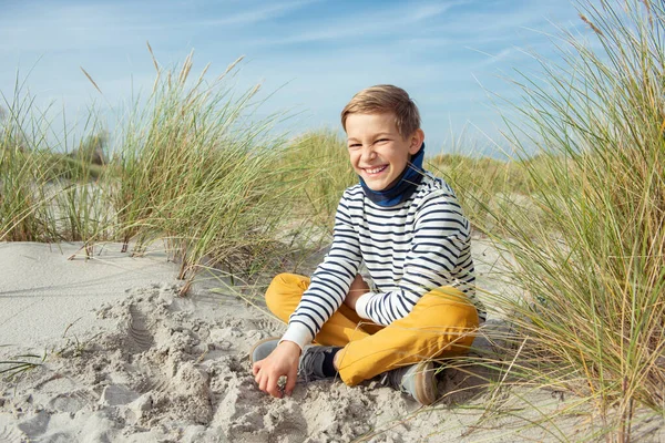 ハンサムなティーンの男の子の肖像 晴れた日にバルト海のビーチで白い砂の上に座って — ストック写真