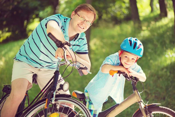 Lycklig Far Och Son Rida Cyklar Sommarparken — Stockfoto