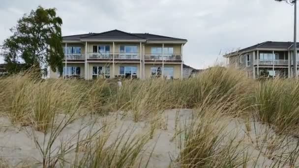 バルト海沿岸の北ドイツの近代的な家の上に砂丘草をふるいます — ストック動画