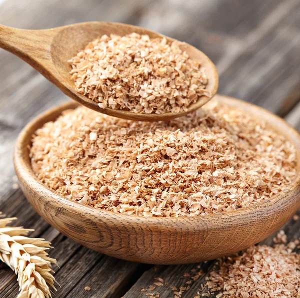 Wheat bran on a wooden background — Stock Photo, Image