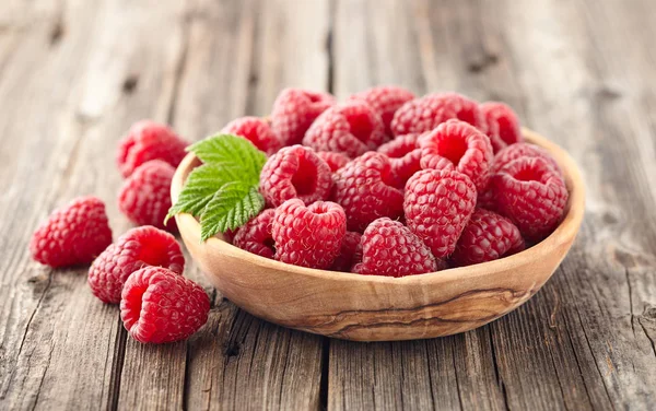 Raspberries in a wooden plate — Stock Photo, Image