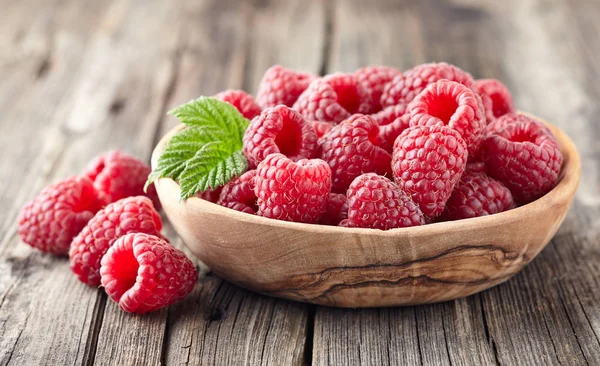 Raspberries in a plate of olive tree — Stock Photo, Image