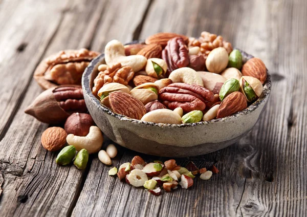 Nueces mezcladas sobre una tabla de madera — Foto de Stock