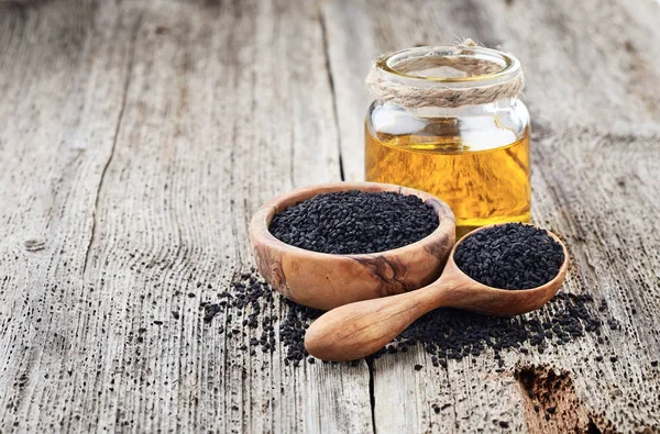 Black cumin oil with seeds — Stock Photo, Image