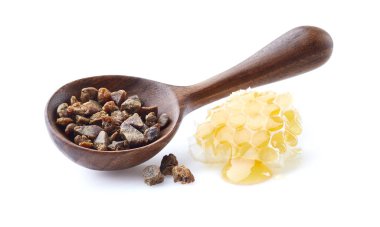 Beyaz arkaplanda bal peteği olan Propolis granülü