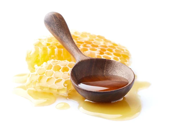 蜂窝与蜂蜜滴和木制勺子在特写镜头 — 图库照片