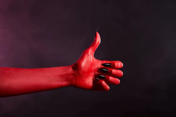 Mano roja del diablo mostrando pulgares hacia arriba — Foto de Stock