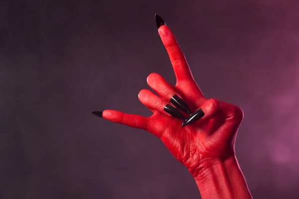 Red devil hand with black nails — Stock Photo, Image