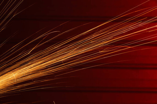 Angle grinder sparks, indoors shoot over red metal background