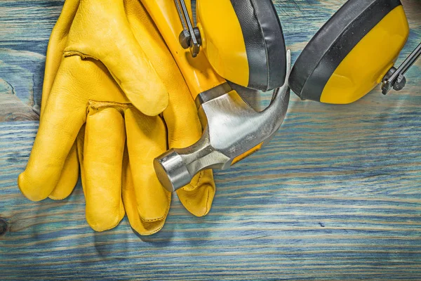 Cuero amarillo guantes de seguridad orejeras garra martillo en boa de madera —  Fotos de Stock