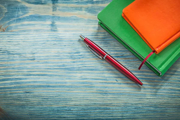 Блокноты и ручка на деревянной доске — стоковое фото