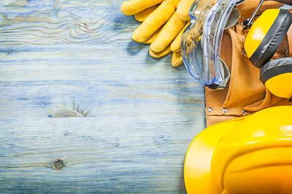 Orejeras gafas protectoras guantes cinturón de herramientas de sombrero duro en madera — Foto de Stock