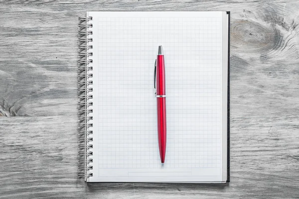 Έλεγξα κενό σημειωματάριο κόκκινο στυλό πάνω σε ξύλινη σανίδα γραφείο έννοια — Φωτογραφία Αρχείου