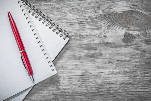 Checked note-books biro pen on wooden board office concept — Stock Photo, Image