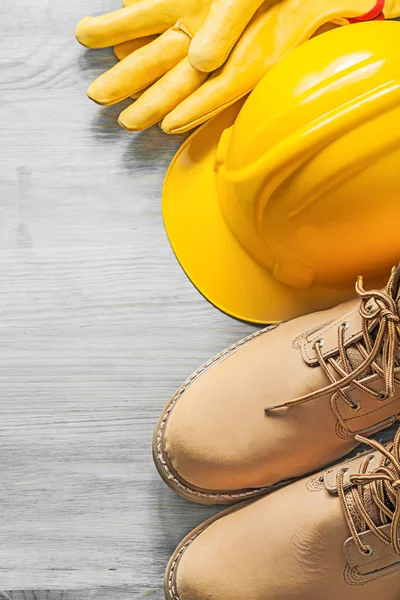 Waterdichte lace laarzen hard hat beschermende handschoenen op houten plank — Stockfoto