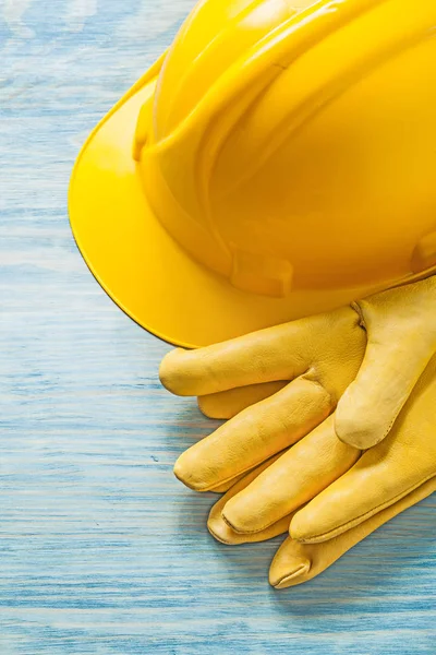 Yellow hard hat safety gloves on wooden board construction conce — Stock Photo, Image