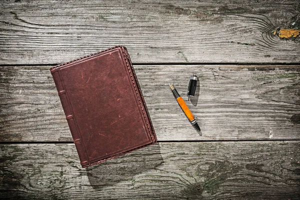 Blocco note vintage e penna stilografica su vecchie tavole di legno — Foto Stock