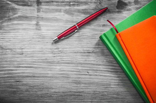 Note-books pen on wooden board education concept