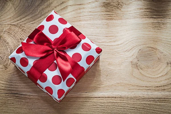 Regalo en caja con cinta roja en concepto de vacaciones de tablero de madera —  Fotos de Stock