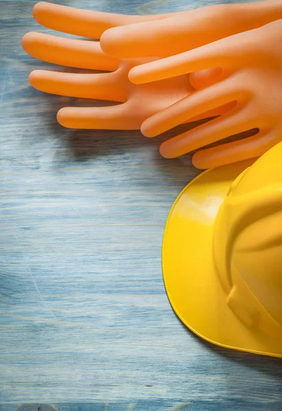 Dielectric gloves hard hat on wooden board electricity concept — Stock Photo, Image