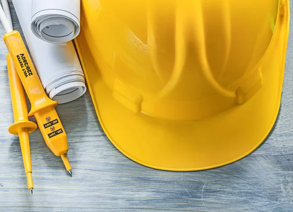 Electric tester protective hard hat engineering drawings on wood — Stock Photo, Image