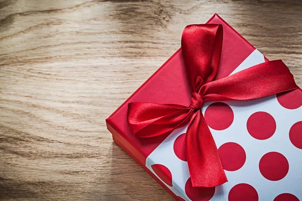 Подарункова коробка з червоним бантом на дерев'яній дошці концепції святкування — стокове фото