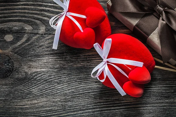 Caja de regalo con lazo atado corazones rojos en paquete de madera vintage — Foto de Stock