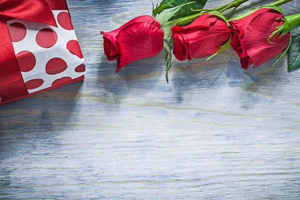 Подарочная коробка из натуральных красных роз в праздничные дни на деревянной доске — стоковое фото