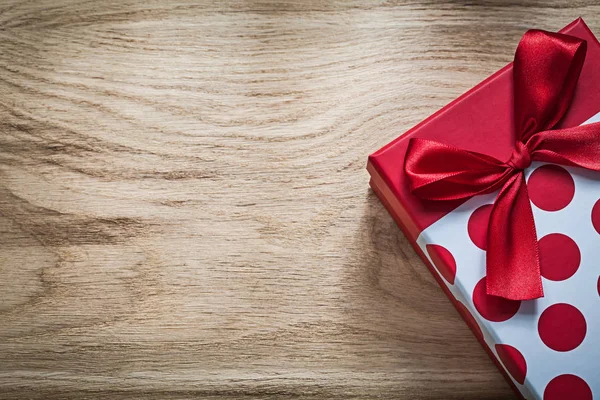 Caja de regalo con lazo rojo en concepto de vacaciones de madera —  Fotos de Stock