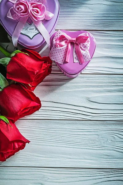 Metal em forma de coração presente caixas rosas vermelhas na placa de madeira celeb — Fotografia de Stock