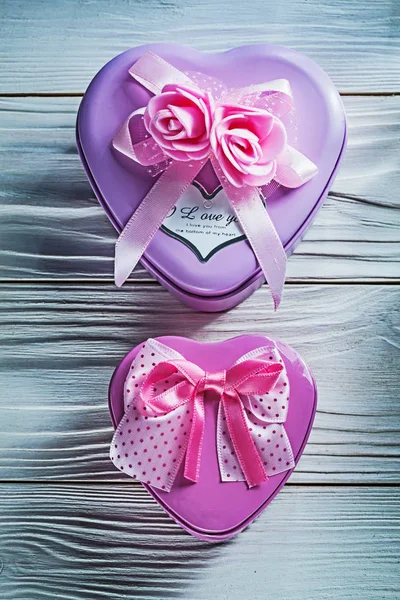 Металева серцеподібна маленька подарункова коробка з рожевими стрічками на дереві — стокове фото