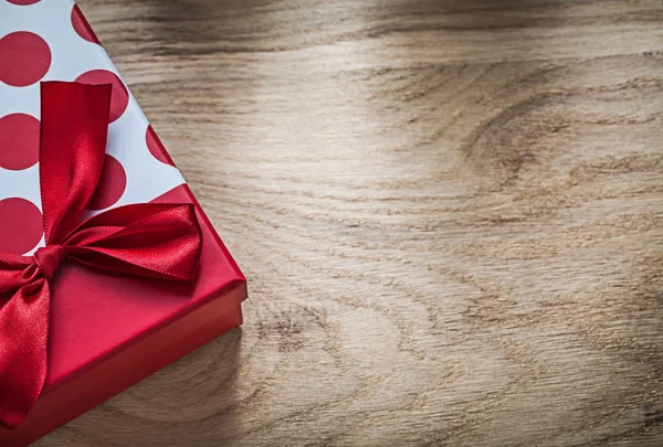 Emballé boîte cadeau avec noeud rouge sur bois bord vacances concéder — Photo