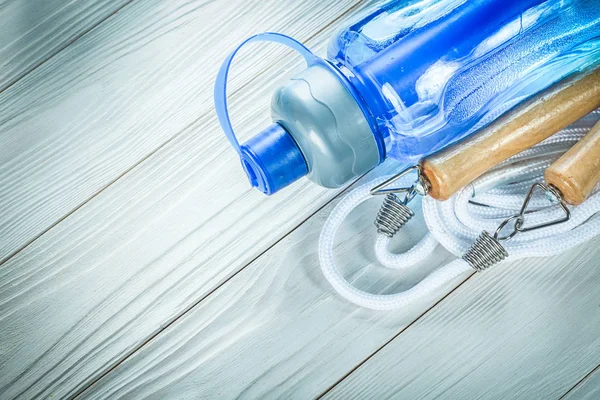 Corda di salto bottiglia d'acqua su tavola di legno allenamento sportivo concep — Foto Stock