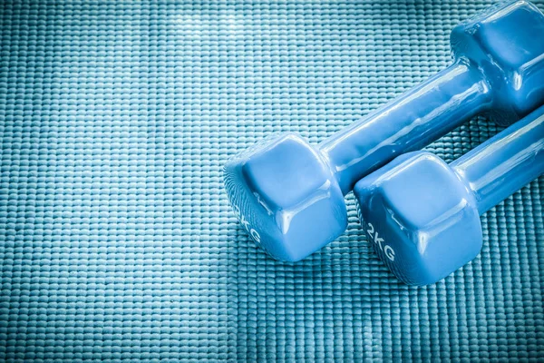 Halteres em fundo azul conceito de treinamento de esportes — Fotografia de Stock