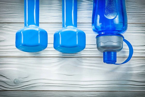 Botella de agua Dumbbells sobre tabla de madera concepto de entrenamiento deportivo — Foto de Stock