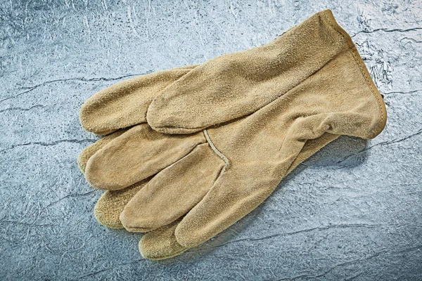 Kožené rukavice na kovové pozadí budování koncepce — Stock fotografie