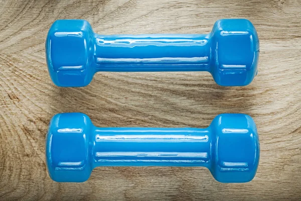 Pesos dumbbell azul no conceito de treinamento de esportes de madeira bordo — Fotografia de Stock