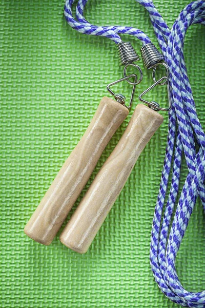 Jump rope on green background fitness concept — Stock Photo, Image