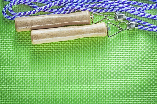 Saltando corda com alças de madeira na superfície verde esportes traini — Fotografia de Stock