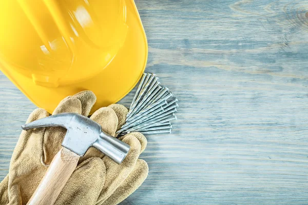 Hard hat safety gloves claw hammer nails on wooden board constru — Stock Photo, Image