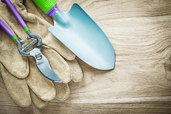 Skyddande handskar av läder och beskärning sax hand spade på trä bo — Stockfoto