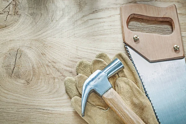 Кожаные перчатки из нержавеющей ножовки на деревянной ножовке — стоковое фото