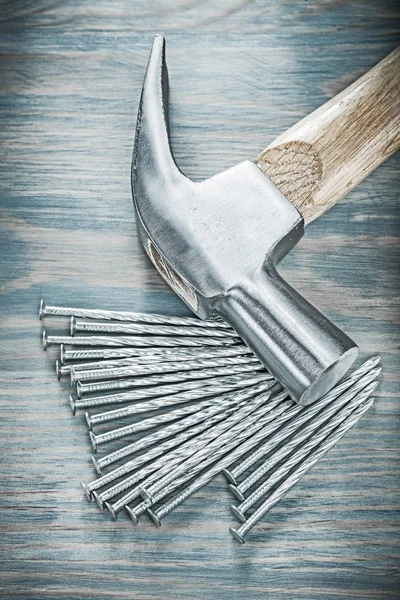 Claw hammer pile of nails on wooden board construction concept