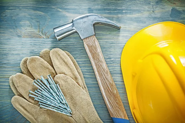 Pair of protective gloves claw hammer nails building helmet on w — Stock Photo, Image